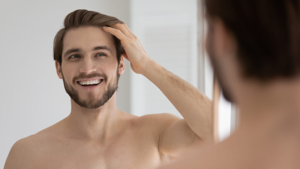 Man admiring growing hair after exosome injections for hair loss